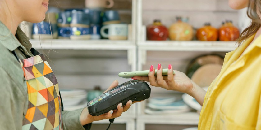 En person betalar med hjälp av en telefon i en butik